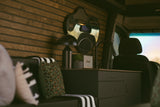 Stylish RV rental interior featuring wood slat walls, a compact kitchen with a sink & Marshall speaker, and plush seating.