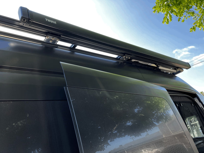 Dark RV rental featuring a rooftop Thule awning, LED light bar, and side mesh screen. — photo 7