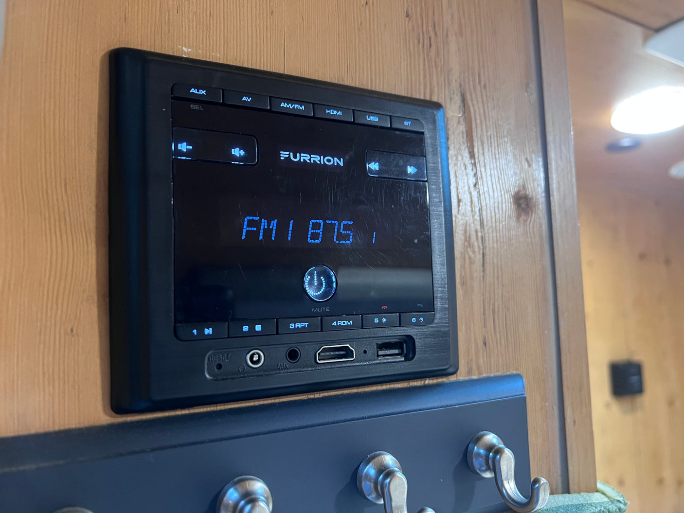 Furrion RV entertainment system, ideal for an rv rental, displays FM 87.5 with AUX, USB, and HDMI ports visible.