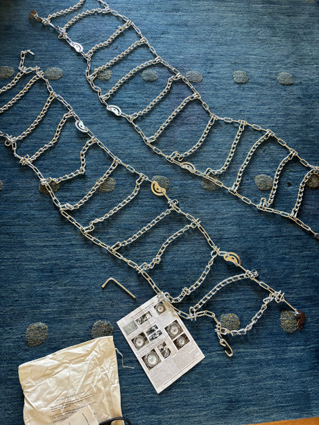 Silver tire chains, instructions, & tools laid out; vital for rv rental safety in snowy conditions.