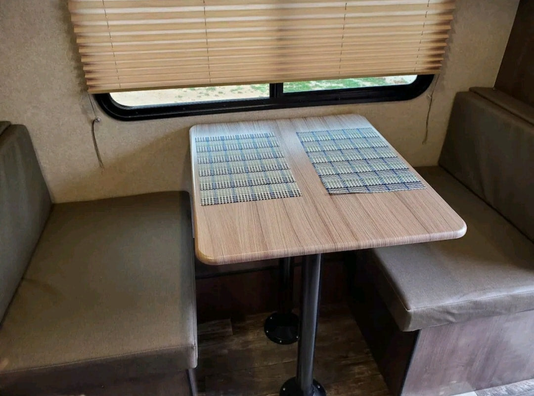 RV rental dinette: a cozy dining area with a table, bench seats, and two placemats, ready for use. — photo 7