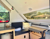 Compact A-frame rv rental interior: dining nook, Magic Chef fridge, and bright windows.