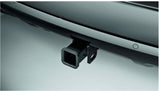 A dark vehicle's rear bumper features a square trailer hitch receiver, ideal for RV rental and towing. Parking sensors are also present.