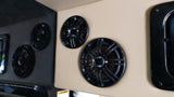 Black speakers mounted on beige and glossy black panels inside an RV rental. Enhanced audio for your adventures.