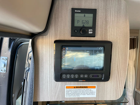 Essential RV rental controls: Truma heater, BMPRO touchscreen for lights/climate, plus safety warning for occupancy.