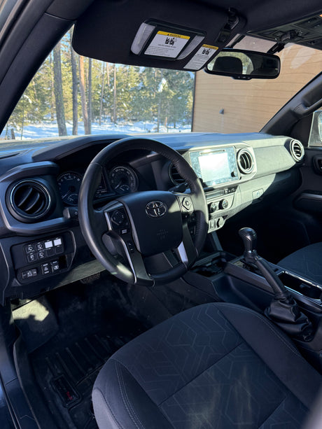 Toyota Tacoma interior with custom switches and WeatherTech mats. Ideal vehicle for your RV rental road trip.