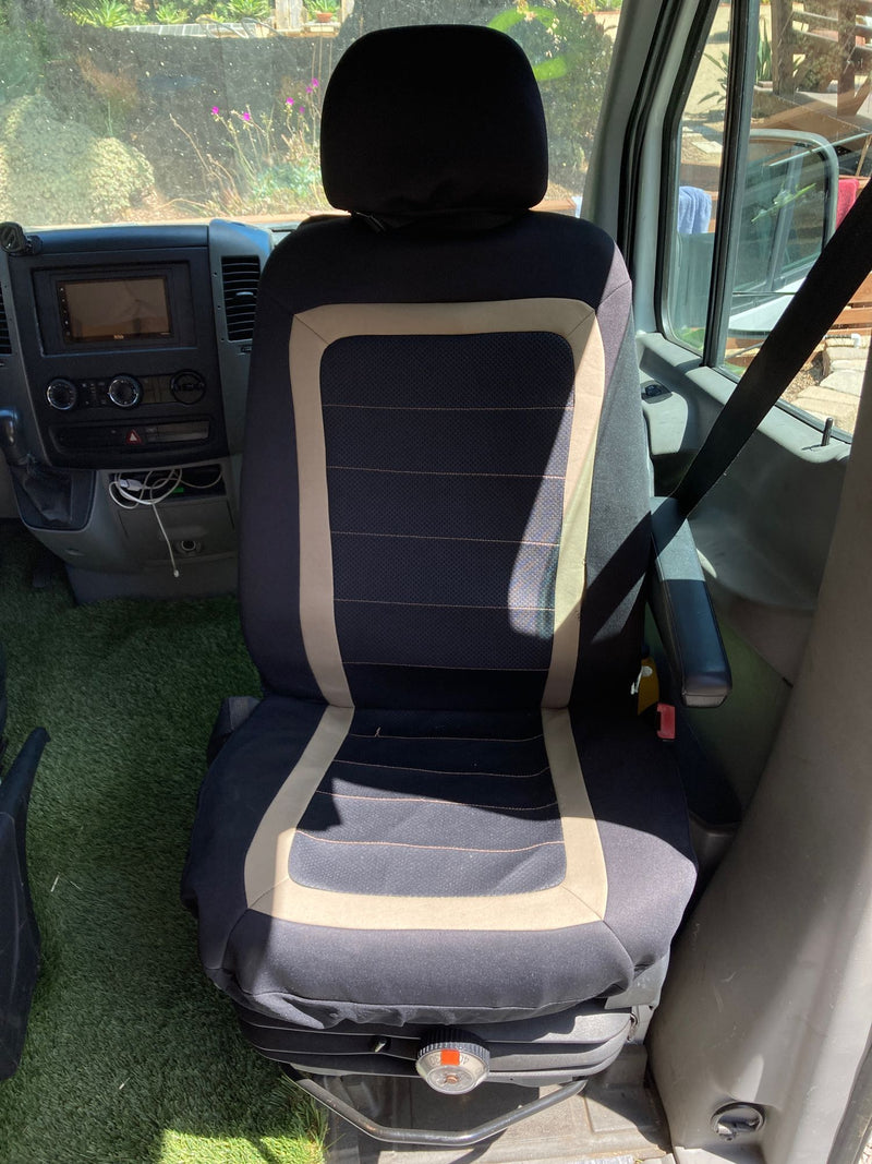 An RV rental driver's seat features a unique artificial grass floor, dashboard, and view of the outdoors. — photo 19