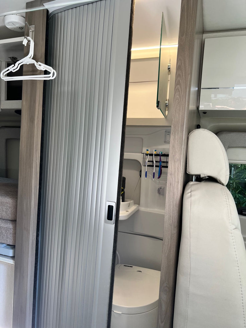  ideal for comfortable meals on your road trip.|Modern RV rental interior: well-equipped kitchen with stovetop — photo 14