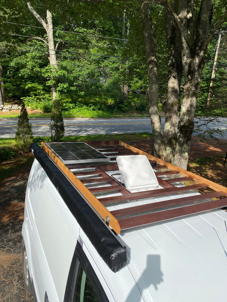 This RV rental features a roof-mounted solar panel, awning, and vent, ready for off-grid adventures.