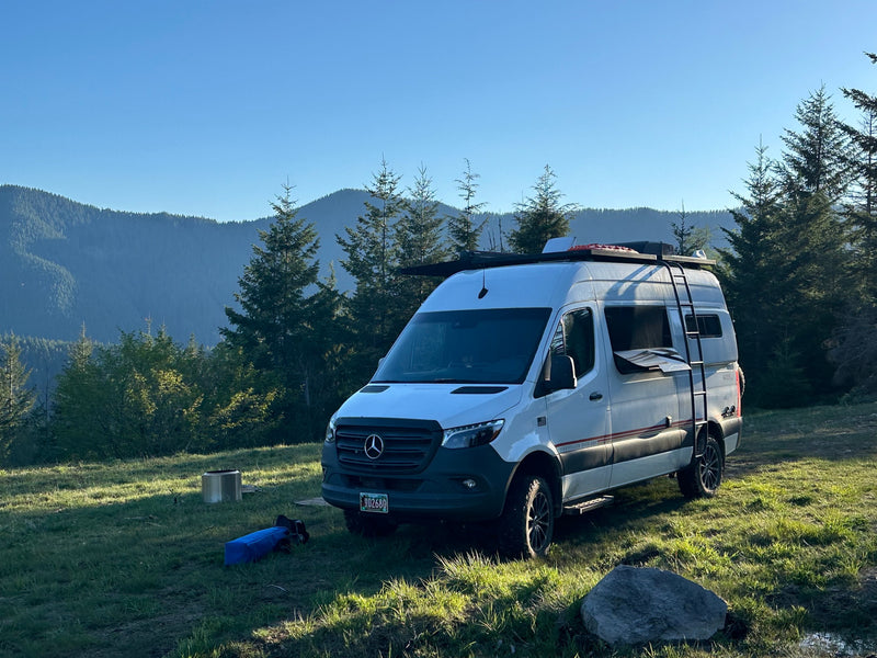  cloud-filled sky.|White Mercedes Sprinter RV rental under clear blue skies — photo 12