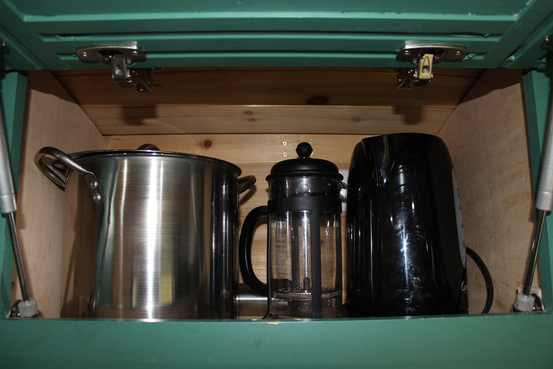 RV rental kitchen cabinet showing a stainless pot, glass French press, and black electric kettle for convenient cooking and coffee. — photo 4