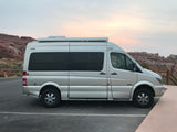 This silver Roadtrek SS Agile camper van is perfect for an RV rental adventure exploring stunning rocky landscapes at dusk.