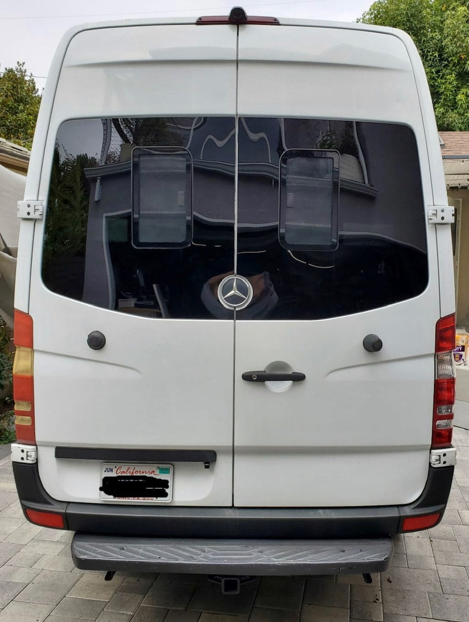 Back of white Mercedes Sprinter van for RV rental. Shows rear doors, tinted windows, and tow hitch, perfect for camper travel. — photo 10
