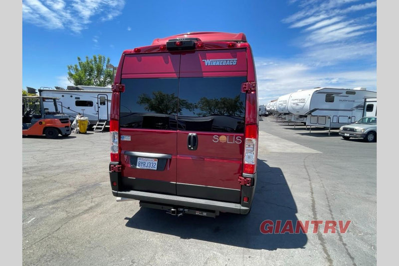  parked outdoors on a sunny day.|This vibrant red pop-top camper van — photo 4
