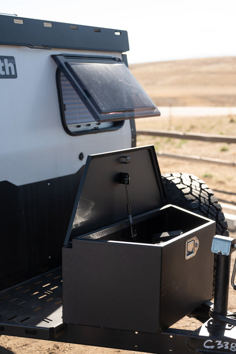 This off-road camper, ideal for RV rental adventures, boasts an open window, rear storage, and spare tire.
