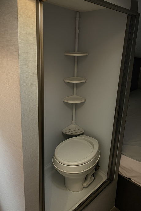 Compact RV rental wet bath featuring a toilet and space-saving corner storage shelves, optimized for small interiors.