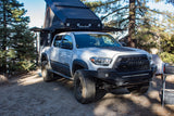 Rugged white Toyota Tacoma overlanding truck with Alu-Cab camper, great for RV rental adventures in the wild.