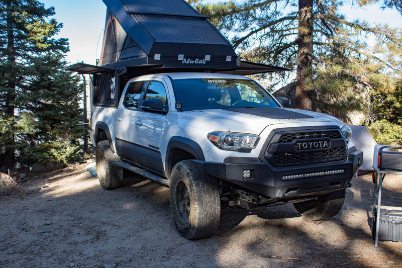 Rugged white Toyota Tacoma overlanding truck with Alu-Cab camper, great for RV rental adventures in the wild. — photo 8