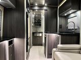 Inside a sleek rv rental: modern kitchen, compact bathroom vanity, and comfy seating in a contemporary design.