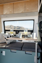 Enjoy the scenic view from this cozy camper van dining area, perfect for your next rv rental adventure. Features a Lagun table.