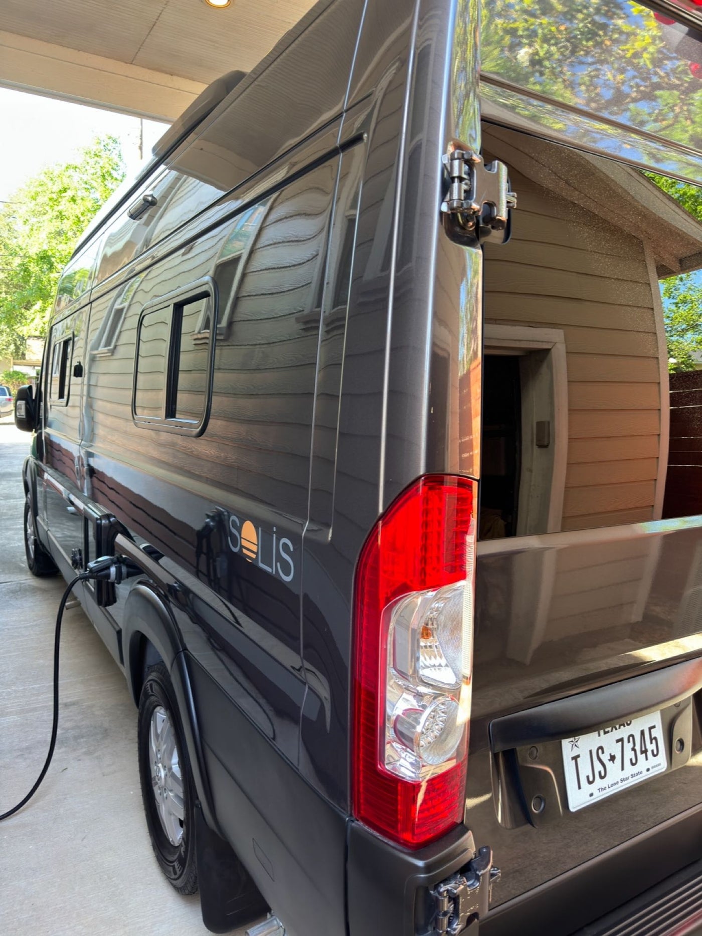  parked in Texas.|Winnebago Solis rv rental: rear view of a grey camper van with rooftop AC & Texas plate — photo 6