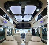 Experience luxury rv rental with this spacious van interior featuring plush seating, sleek lighting, and modern design.
