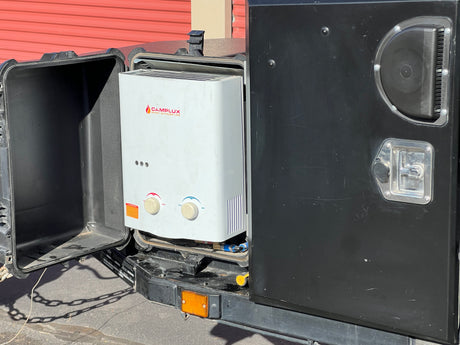 A Camplux portable water heater is visible inside an open compartment, indicating outdoor shower capability for this RV rental.