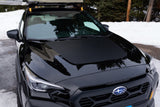 Front of black Subaru with roof rack/awning, parked in snow. An adventure vehicle for winter trips, similar to an RV rental.