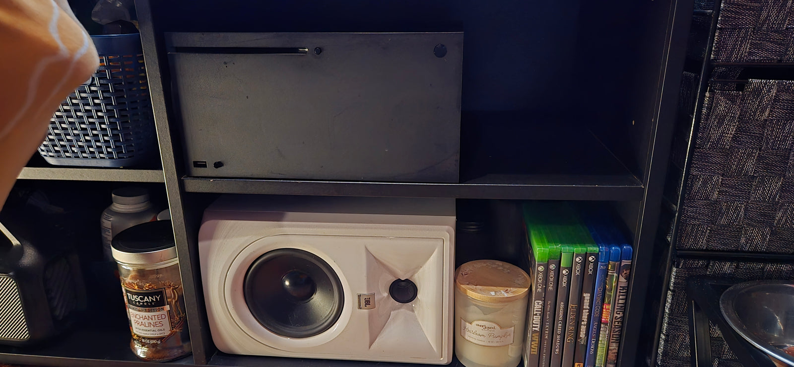 Organized shelf with Xbox, JBL speaker, games, and candles. Ideal for compact spaces or an RV rental setup.