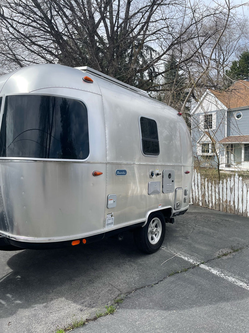  and window view with emergency exits.|Enjoy this clean RV rental interior with dining table and cozy benches — photo 9