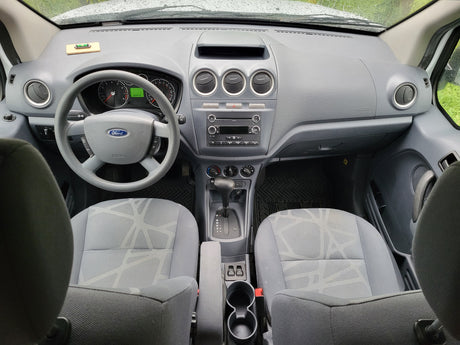 Ford Transit Connect van interior: dashboard, steering wheel, front seats, and automatic transmission. Ideal for an RV rental or work vehicle.
