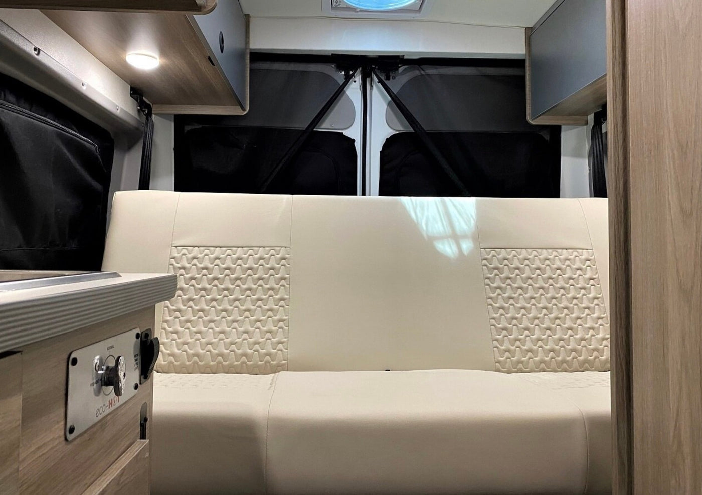 RV rental interior: A comfy cream bench seat, with Eco-Hot controls and rear privacy blinds, ideal for your next trip. — photo 5