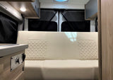 RV rental interior: A comfy cream bench seat, with Eco-Hot controls and rear privacy blinds, ideal for your next trip.