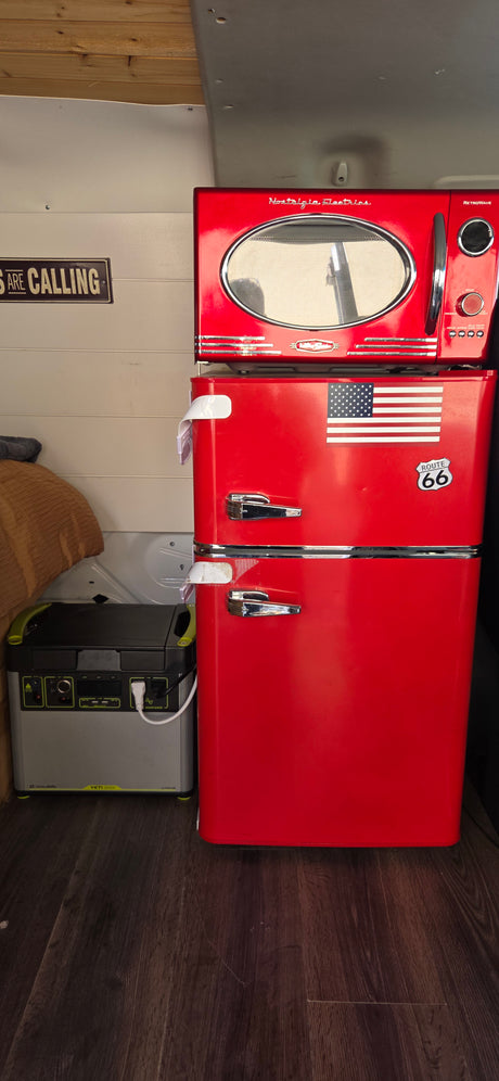 Inside an RV rental: a red retro microwave atop a fridge, powered by a Goal Zero Yeti 3000X portable station for travel.
