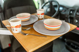 Cozy meals on the go! This RV rental features a convenient pull-out table with two colorful place settings for your adventure.
