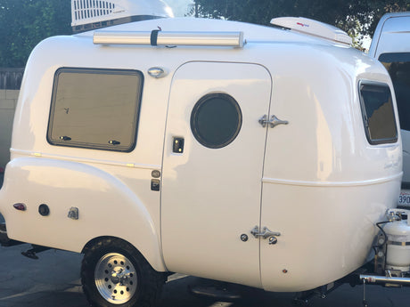A white compact Happier Camper HC1 teardrop travel trailer, with roof AC and fan. Perfect compact rv rental.