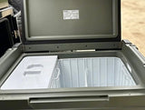 Open Truma portable fridge/freezer, showing white interior, partition, and basket. Perfect for your rv rental.