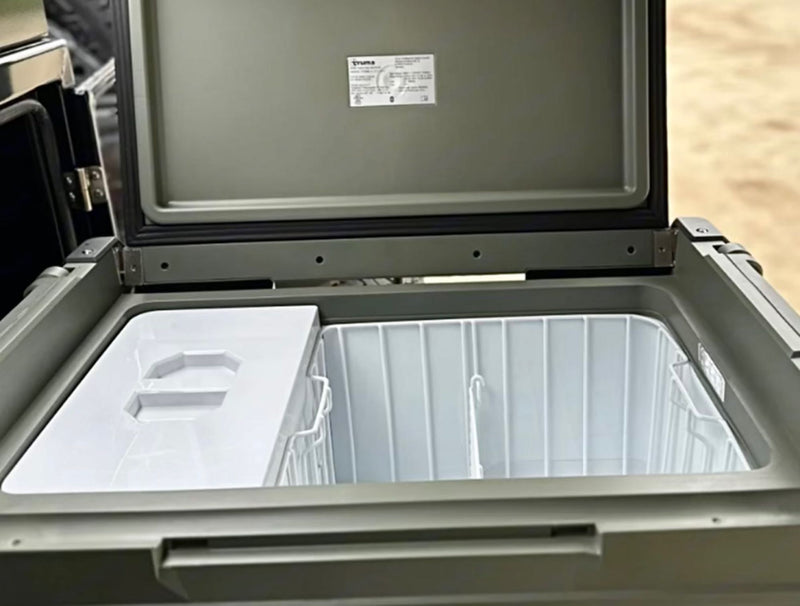 Open Truma portable fridge/freezer, showing white interior, partition, and basket. Perfect for your rv rental. — photo 8