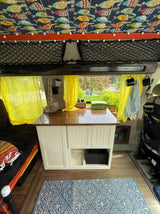  and bright yellow curtains for travel.|Unique RV rental interior with colorful bird-patterned ceiling