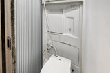 Clean, compact RV rental wet bath. Includes a Thetford toilet, shower, and switches for light & fan, with a ribbed sliding door.