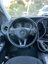 Driver's perspective inside a modern Mercedes-Benz van, highlighting the steering wheel and dashboard, ideal for an rv rental.