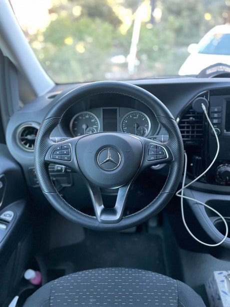 Driver's perspective inside a modern Mercedes-Benz van, highlighting the steering wheel and dashboard, ideal for an rv rental.