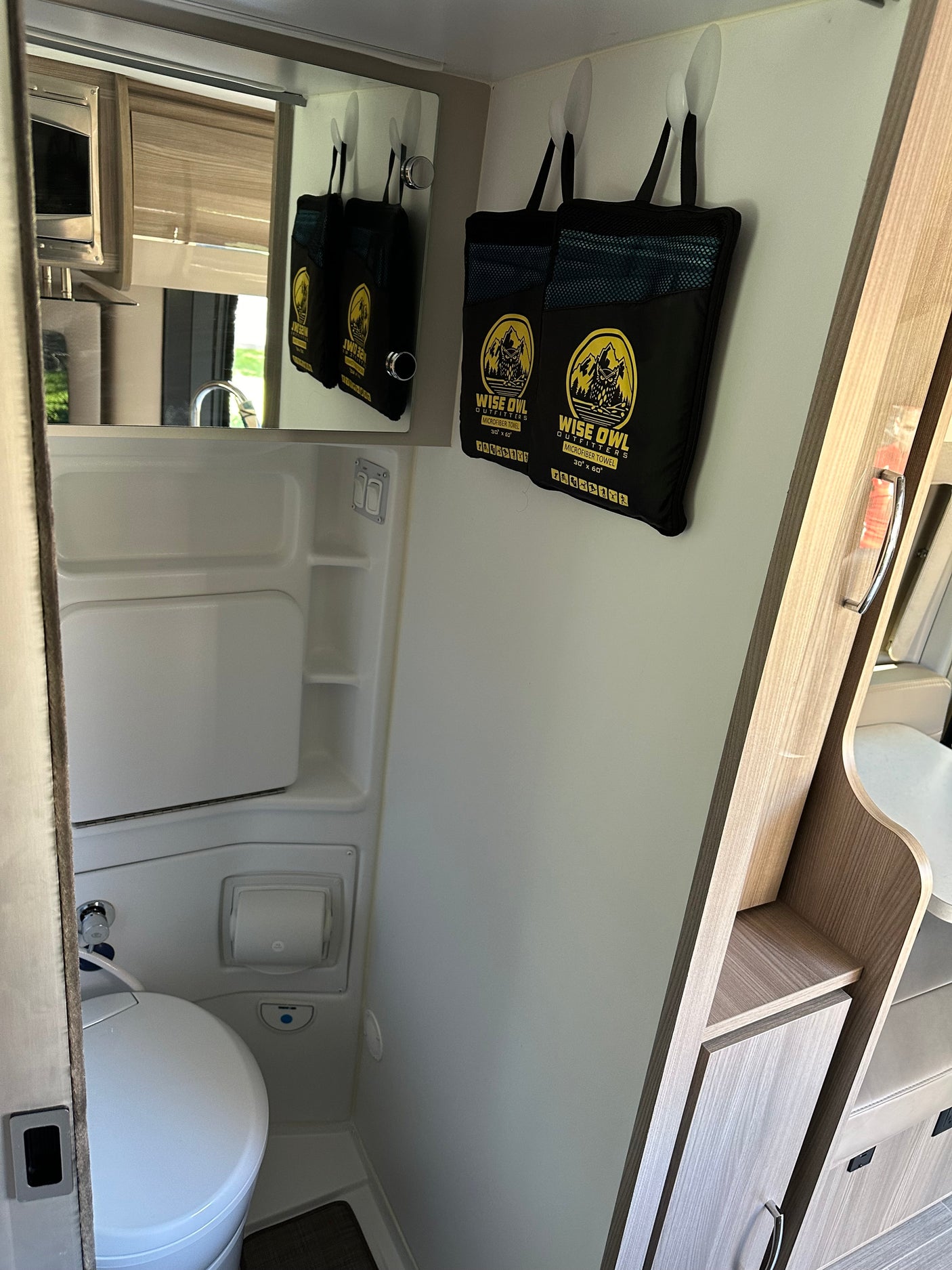 RV rental's compact interior features a bathroom with toilet and integrated shower, plus Wise Owl microfiber towels.