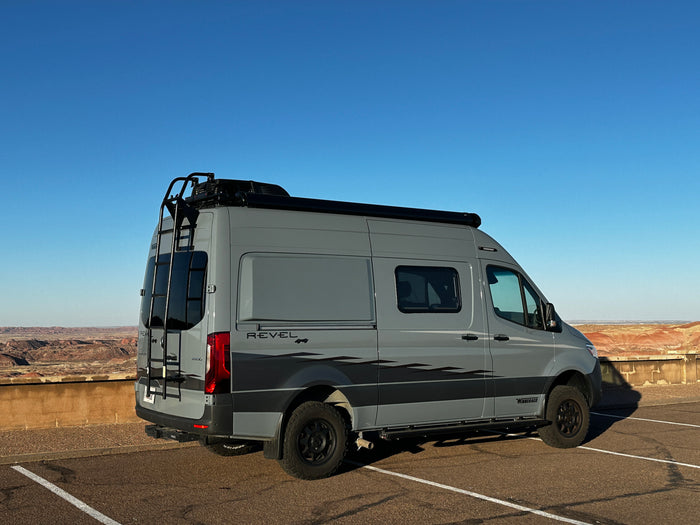 Exploring with an RV rental: a gray Winnebago Revel camper van parked at a scenic desert overlook.
