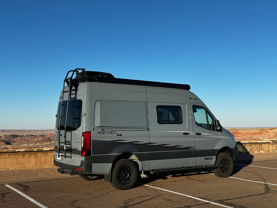 Exploring with an RV rental: a gray Winnebago Revel camper van parked at a scenic desert overlook.