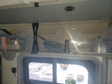 RV rental interior showing organized overhead storage with clear bins, kitchenware, a weBoost, and snowy outdoor view.