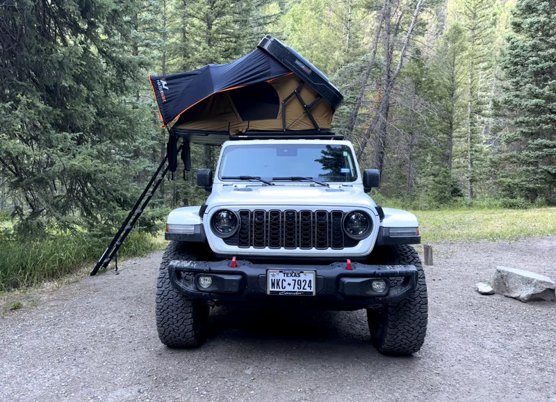White Jeep with a deployed rooftop tent — photo 1