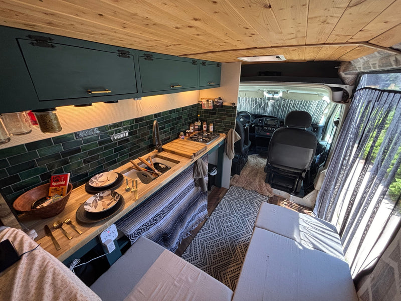 Custom rv rental camper van interior: a cozy kitchen, wood ceiling, and seating area for travel adventures. — photo 6