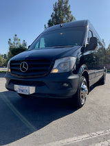 A sleek black Mercedes-Benz Sprinter van, great for RV rental. Parked outside with California plate 7PHW035 visible.