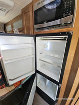 **RV rental** kitchen showing an open, empty refrigerator and microwave oven, ready for use.